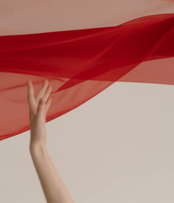 Woman in a graceful flowing movement against a warm background.